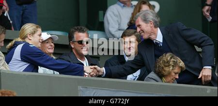 KEINE KOMMERZIELLE NUTZUNG. Tony Henman, der Vater des britischen Tim Henman (rechts) schüttelt sich die Hände mit Kim Clijsters am Center Court in Wimbledon. Clijsters ist die Freundin des Topseed Lleyton Hewitt aus Australien, der Henman im Halbfinale spielt. Regen zwang die Spieler nach ihrem 5-minütigen Warm-up, ohne einen einzigen Punkt zu spielen, auf den Platz. Stockfoto