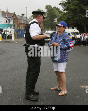 Ein loyalistischer Unterstützer spricht mit einem Polizeibeamten, während er eine Parade des Orangenen Ordens auf der Crumlin Road neben dem nationalistischen Ardoyne-Viertel im Rahmen der jährlichen Feierlichkeiten zum 12. Juli erwartet. Markiert den Sieg von König Wilhelm III Sieg über James II in der Schlacht von Boyne in 1690. Stockfoto