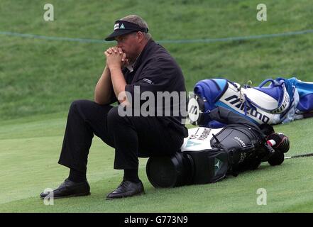 Darren Clarke aus Irland sitzt auf seiner Tasche auf dem 16. Grün während der verzögerten zweiten Runde der Wales Open auf dem Wentwood Hills Kurs im Celtic Manor Resort in der Nähe von Newport, Südwales. Stockfoto