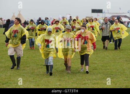 Festivalbesucher tragen Ponchos während einer Regendusche beim T in the Park Festival, das im Balado Park in Kinross, Schottland, stattfindet. Stockfoto