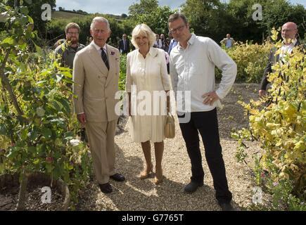 Der Prinz von Wales und die Herzogin von Cornwall mit Küchenchef und Sender Hugh Fearnley-Whittingstall während einer Tour durch das River Cottage HQ Restaurant in Axminster, Devon. Stockfoto