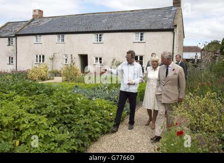 Der Prinz von Wales und die Herzogin von Cornwall mit Küchenchef und Sender Hugh Fearnley-Whittingstall während einer Tour durch das River Cottage HQ Restaurant in Axminster, Devon. Stockfoto