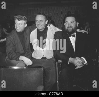 Drei der Royal Variety Performance-Stars (l-r), Sänger und Schauspieler Tommy Steele (mit dem Comedy-Musiker „Half A Sixpence“), Komiker Dickie Henderson und Comicschauspieler Michael Flanders (mit seinem Partner Donald Swann) Beobachten Sie an den Ständen, wie andere Künstler im Prince of Wales Theatre in London für die Show Proben. Stockfoto