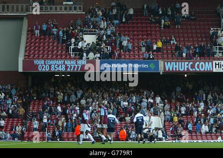 Leere Plätze in den Tribünen, als West Ham-Fans vor dem Schlusspfiff nach Hause fahren, als Hammers Jermain Defoe (links) und Frederic Kanoute (rechts) am Ende des Unentschieden 0-0 gegen einen Besuch in Manchester City ausziehen, Während ihres FA Barclaycard Premiership Spiels auf West Hams Upton Park Ground in London. Stockfoto