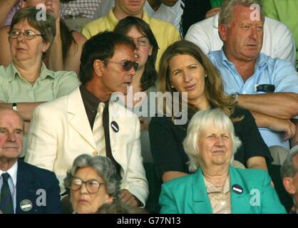 , NICHT FÜR MOBILTELEFONE geeignet Sir Cliff Richard und die ehemalige Wimbledon-Meisterin Steffi Graff beobachten Steffis Ehemann Andre Agassi auf dem Center Court gegen den Briten Jamie Delgado bei den All England Lawn Tennis Championships in Wimbledon. Stockfoto