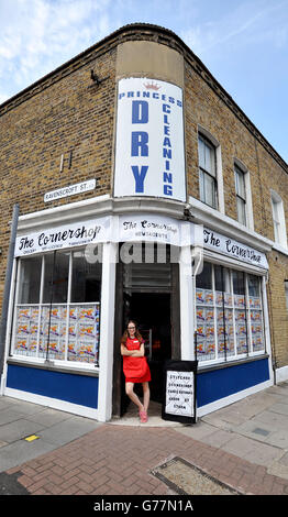 Die Textilkünstlerin Lucy Sparrow steht im Eingangsbereich ihrer Kunstinstallation, dem Cornershop in Wellington Row, Bethnal Green, East London, wo fast 2,000 klassische Lebensmittel im Inneren aus Filz handgefertigt und als Kunstwerk zum Verkauf stehen. Stockfoto