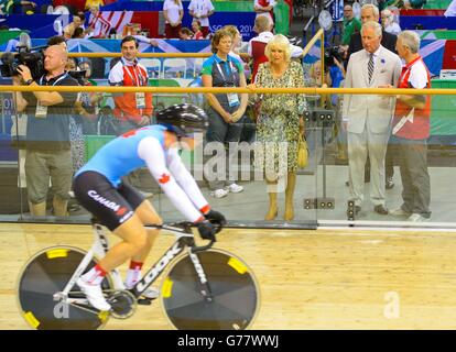 Der Prinz von Wales und die Herzogin von Cornwall beobachten ein Mitglied der kanadischen Rennradmannschaft bei einem Besuch der Emirates Arena und des Sir Chris Hoy Velodrome in Glasgow, Schottland, vor der Eröffnungszeremonie bei den Commonwealth Games 2014 in Glasgow. Stockfoto