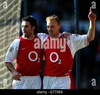 Dennis Bergkamp von Arsenal (rechts) feiert mit Teamkollege Robert Pires, nachdem er bei seinem FA Barclaycard Premiership-Spiel auf dem Maine Road Ground von Manchester City gegen Manchester City Punkten konnte. Stockfoto