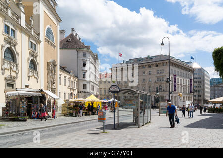 Straßenszene von Freyung Platz mit Menschen, Kunstforum, Bushaltestelle und Markt Stände im alten Stadtzentrum von Wien, Österreich Stockfoto