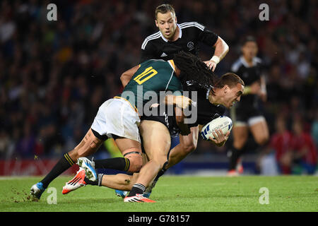 Der Südafrikaner Cecil Afrika (links) tritt dem Neuseeländer Joe Webber (rechts) im Rugby Sevens Finale im Ibrox Stadium während der Commonwealth Games 2014 in Glasgow an. Stockfoto