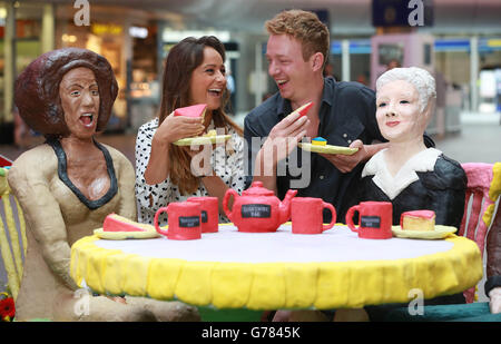 (Von links nach rechts) Natalie Grundy und Oli Carew interagieren mit der Yorkshire Tea Party &ETH; Eine Kuchenkunstinstallation mit Mel B und Judi Dench, Jarvis Cocker und Louis Tomlinson, die von Yorkshire Tea in Auftrag gegeben wurde, um den 39. Jährlichen Yorkshire Day an der King's Cross Station in London zu feiern. Stockfoto