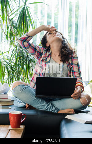 Frau haben Kopfschmerzen, arbeiten von Zuhause, helles sonniges Zimmer Stockfoto