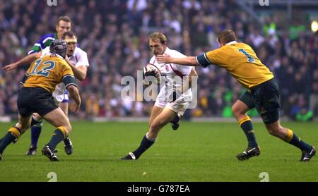 Der Engländer Matt Dawson, der zum „man of the Match“ gemacht wurde, der kurz vor einem Tackle von Bill Young und Elton Flatley aus Australien während des Internationalen Freundschaftsspiel in Twickenham, London, stehen wird. Stockfoto