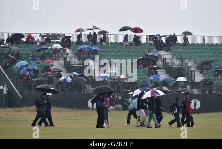 Bei nassem Wetter machen sich die Zuschauer am dritten Tag der Open Championship 2014 im Royal Liverpool Golf Club, Hoylake, auf den Weg durch den Platz. Stockfoto