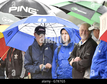 Am dritten Tag der Open Championship 2014 im Royal Liverpool Golf Club, Hoylake, schützen sich die Zuschauer vor Regen. Stockfoto