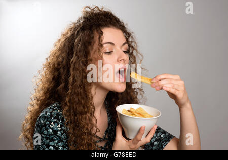 Teenager, die Kartoffel-Chips aus einer Schüssel essen Stockfoto