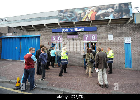 Die Fans stehen vor dem Spiel in der Schlange, um durch die Drehkreuze zu gehen Stockfoto