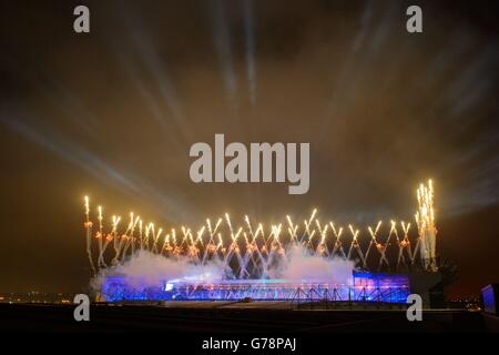 Während der Eröffnungszeremonie der Commonwealth Games 2014 erleuchtet ein Feuerwerk den Himmel über dem Celtic Park, vom Sir Chris Hoy Velodrome Dach aus gesehen. Stockfoto