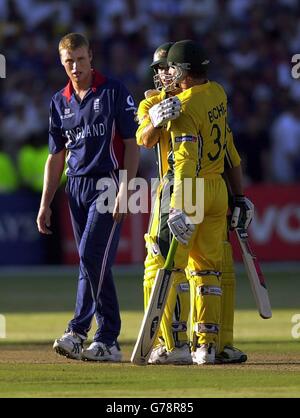 Der Engländer Andrew Flintoff sieht zu, wie sich die Australier Michael Bevan (Mitte) und Andy Bichel umarmen, nachdem sie ihr letztes Spiel der Gruppe A Cricket World Cup mit 2 Wickets im St. George's Park, Port Elizabeth, gewonnen haben. Pakistan muss Simbabwe in Bulawayo schlagen, damit England jede Chance hat, zu den Super-Sechsen zu kommen. Stockfoto