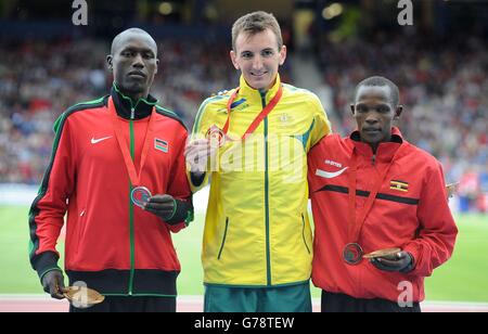 Der australische Michael Shelley (Mitte) feiert mit seiner Goldmedaille, neben dem Silbermedaillengewinnerer Stephen Chemlany aus Kenia und dem Bronzemedaillengewinnerer Abraham Kiplimo aus Uganda nach dem Men's Marathon im Hampden Park während der Commonwealth Games 2014 in Glasgow. Stockfoto