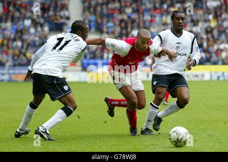 Arsenals Thierry Henry (Mitte) in Aktion gegen Bolton Wanderers' Ricardo Gardener (links) und Jay Jay Okocha, während des Barclaycard Premiership Spiels im Reebok Stadium, Bolton. Stockfoto