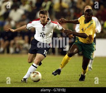 Der englische Michael Owen (links) übertrifft den südafrikanischen Verteidiger Aaron Mokoena bei ihrem Freundschaftsspiel im ABSA-Stadion von Durban zwischen Südafrika und England, Durban, Südafrika. Stockfoto