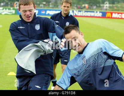 Englands Wayne Rooney (links) und John Terry (rechts) Ausfallschritt für den Ball, beobachtet von Michael Owen während des Trainings im Rockcliffe Park in Darlington. Stockfoto