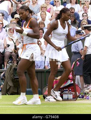 Die Titelverteidigerin Serena Williams (links) und ihre Schwester Venus kreuzen sich während des Damenfinales bei den All England Lawn Tennis Championships in Wimbledon auf dem Platz. Stockfoto