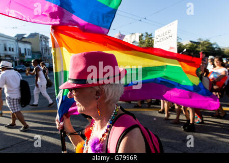 San Francisco, Kalifornien, USA. 25. Juni 2016. Ein Marcher trägt eine Regenbogenfahne während des Marsches Deich. Bildnachweis: John Orvis/Alamy Live-Nachrichten Stockfoto