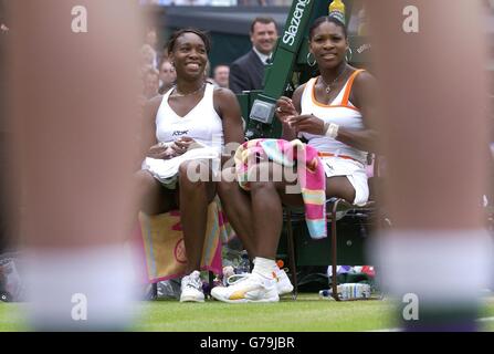 KEIN HANDY. Titelverteidigerin Serena Williams (rechts) mit ihrer Schwester Venus, nachdem sie das Damenfinale bei den All England Lawn Tennis Championships in Wimbledon gewonnen hatte. Endergebnis 4:6/6:4/6:2. Stockfoto