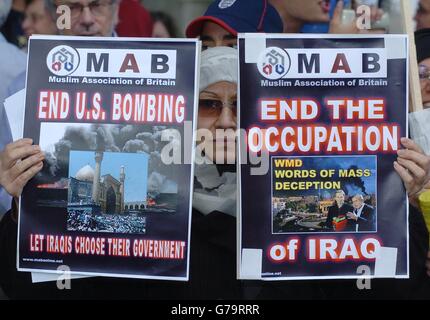 Eine Frau hält zwei Plakate, während sie sich Dutzenden von Demonstranten vor der Downing Street anschließt, um ein Ende des Kampfes in Najaf und den Abzug der Koalitionstruppen aus dem Irak zu fordern. Dutzende Mitglieder der Stop the war Coalition, der Muslimischen Vereinigung Großbritanniens und der Kampagne für nukleare Abrüstung versammelten sich, um Banner zu schwingen und "George Bush Out of Najaf" zu singen. Der ehemalige Labour-Abgeordnete George Galloway nahm an dem Protest gegen das Teil, was er den "Massaker" in der Stadt Najaf und den weiteren Krieg im Irak nannte. Stockfoto