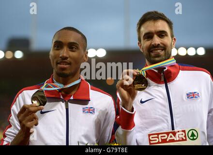 Der britische Martyn Rooney (rechts) feiert auf dem Podium mit seiner Goldmedaille, nachdem er am vierten Tag der Leichtathletik-Europameisterschaften 2014 im Letzigrund-Stadion in Zürich die 400-Meter-Strecke der Männer an den Seiten von Matthew Hudson-Smith mit seiner Silbermedaille gewonnen hatte. Stockfoto