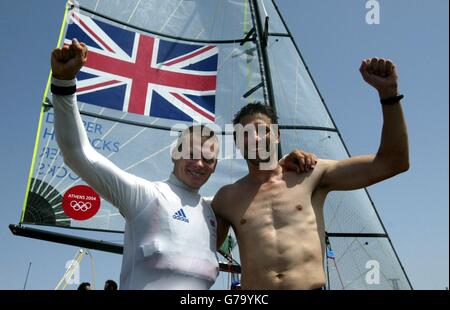 Großbritanniens Bronzemedaille siegreiche 49er Segelcrew (von links) Chris Draper aus Southampton und Simon Hiscocks aus Newdigate, Surrey, feiern im Agios Kosmas Olympic Sailing Center in Athen, Griechenland, nach einem dritten Platz in ihrer Klasse während der Olympischen Spiele. Stockfoto