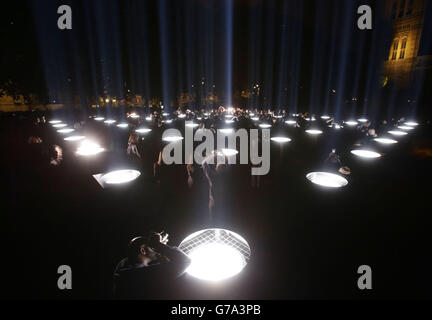 Besucher schauen sich in den Victoria Tower Gardens in London um eine Lichtinstallation namens 'Spectra' - bestehend aus 49 einzelnen Scheinwerfern, die in den Himmel ragen - des japanischen Künstlers Ryoji Ikeda und Artengel. Stockfoto