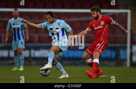 Jim O'Brien von Coventry City stellt sich während des Spiels der ersten Runde des Capital One Cup im Sixfields Stadium in Northampton gegen Aron Gunnarsson von Cardiff City. Stockfoto