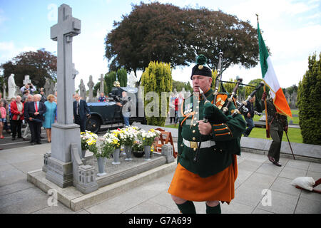 Eine Piper der Verteidigungskräfte marschiert am Grab von Michael Collins vorbei, während der 99. Jährlichen Gedenkfeier von Collins und Arthur Griffith, die heute auf dem Friedhof von Glasnevin in Dublin abgehalten wird. Stockfoto