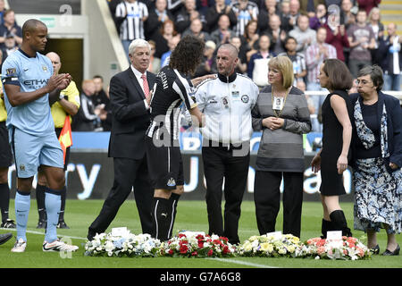 Der Kapitän von Newcastle United Fabrizio Coloccini (Mitte links) begrüßt Barry Sweeney, den Sohn von Liam Sweeney, während einer Hommage an den Unterstützer Liam Sweeney, der sein Leben zusammen mit seinem Fan John Alder bei der Katastrophe des MH17-Fluges von Malaysia Airlines vor dem Spiel der Barclays Premier League im St. James' Park in Newcastle verloren hat. Stockfoto