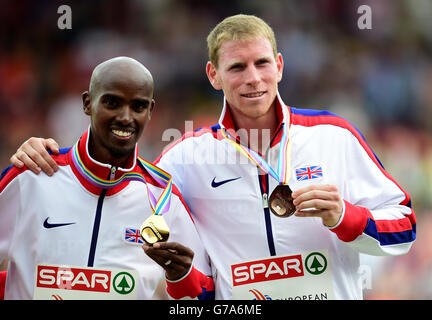 Der britische Mo Farah (links) posiert mit seiner Goldmedaille, die er in den 5000 m der Männer gewonnen hat, und Teamkollege Andy Vernon posiert mit seiner Bronzemedaille am sechsten Tag der Leichtathletik-Europameisterschaften 2014 im Letzigrund-Stadion in Zürich. Stockfoto