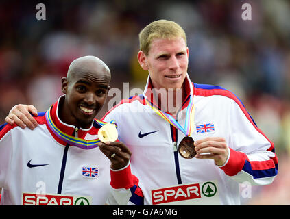 Der britische Mo Farah (links) posiert mit seiner Goldmedaille, die er in den 5000 m der Männer gewonnen hat, und Teamkollege Andy Vernon posiert mit seiner Bronzemedaille am sechsten Tag der Leichtathletik-Europameisterschaften 2014 im Letzigrund-Stadion in Zürich. Stockfoto