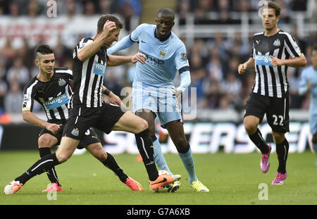 Die Yaya Toure von Manchester City wird von Mike Williamson und Remy Cabella aus Newcastle United während des Spiels der Barclays Premier League im St. James' Park, Newcastle, in seinen Tracks gestoppt. Stockfoto