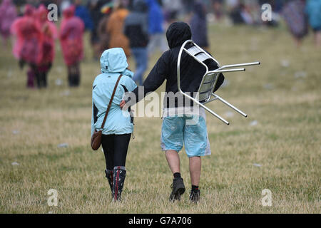 Festivalbesucher machen sich am zweiten Tag des V Festivals im Weston Park in Staffordshire durch den Regen auf den Weg. Stockfoto