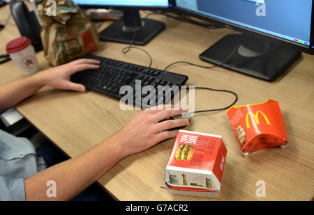 Eine McDonalds Big Mac-Box und Pommes-Kartons sind auf einem Büroarbeitstisch in London zu sehen Stockfoto