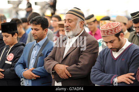 Ahmadiyya Muslime versammeln sich zum Freitagsgebet im Hauptzelt, während sie sich bis zu 30,000 Muslimen anschließen, um während der Jalsa Salana UK 2014 in Alton, Hampshire, dem Kalifen Treue zu versprechen. Stockfoto