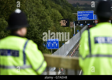 Die Polizei übersieht vor dem NATO-Gipfel in Newport, Wales, die Sicherheitszäune in der Nähe des Celtic Manor Resort an der Kreuzung 24 der Autobahn M4. Stockfoto