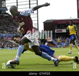 Carlton Cole von Aston Villa schlägt den abstürzenden Verteidiger von Southampton, Claus Lundekvam, während ihres Barclays Premiership-Spiels in Villa Park, Birmingham, am Samstag, 14. August 2004. Stockfoto