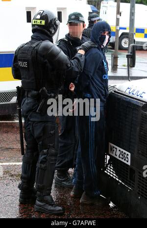 EDS-ANMERKUNG: DAS GESICHT WURDE VOM BILDTISCH der PA VERPIXELT EIN Mann wird festgenommen, weil die Polizei loyalistische Fahnenprompter von einer republikanischen Parade im Stadtzentrum von Belfast getrennt hat, die weitgehend friedlich vorbeigegangen ist. Stockfoto