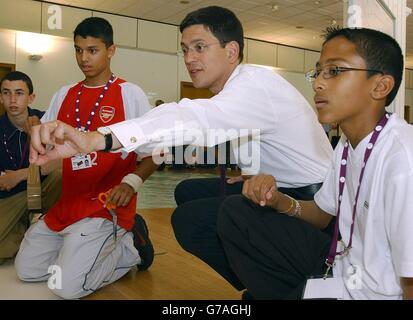 David Miliband MP, School Standards Minister steht mit einem Board, das Newtons Gesetze und Fallschirmgesetze Gleichungen zeigt, während eines Besuchs in einer National Academy für begabte und talentierte Jugend Sommerschule am Imperial College London. Er räumte ein, dass Die A-Ebenen reformiert werden müssen, weil sie es den Universitäten nicht ermöglichen, die höchsten Flugblätter zu erkennen, bevor am Mittwoch die A-Level-Ergebnisse dieses Jahres bekannt gegeben werden. Stockfoto