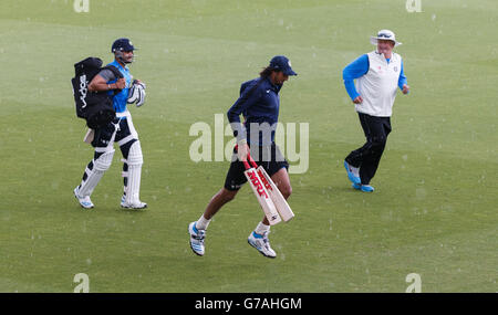 Der indische Ishant Sharma (Mitte) und Trainer Duncan Fletcher laufen vom Spielfeld, während ihre Nets-Session aufgrund eines starken Regensturms im Kia Oval, London, gestoppt wird. Stockfoto