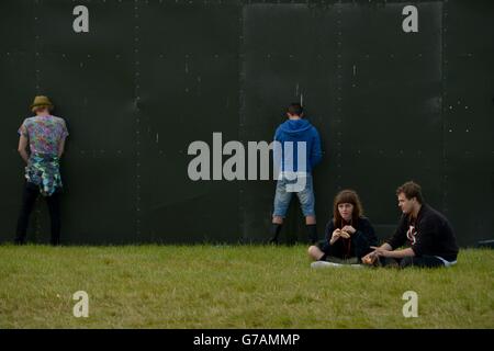 Zwei Festivalbesucher (rechts) essen ihr Mittagessen am zweiten Tag des Leeds Festivals im Bramham Park, Leeds. Stockfoto