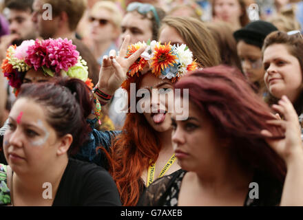 Ein Festivalbesucher, der Laura Mvula beim Auftritt auf der Hauptbühne des Festivals im Robin Hill Adventure Park, Isle of Wight, beobachtet. Stockfoto